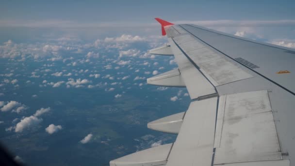 Skrzydło samolotu lecącego nad chmurami. Widok z okna samolotu. — Wideo stockowe