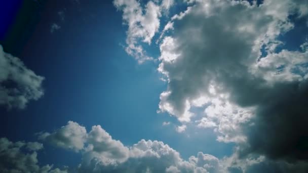 时间流逝：云彩在晴朗的蓝天背景中移动，阳光透过云彩闪耀 — 图库视频影像
