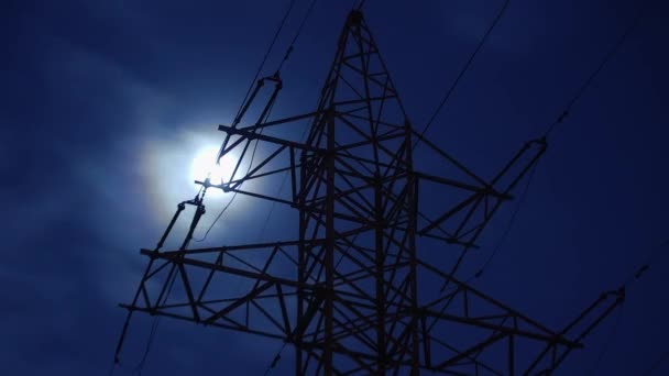 TIMELAPSE: full moon in clouds are moving behind top of electricity pylon — ストック動画