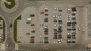 Süpermarketin otoparkındaki bir çok arabanın havadan görünüşü.