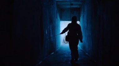 Virologist in hazmat disinfects room from bacteria and diseases in medical lab