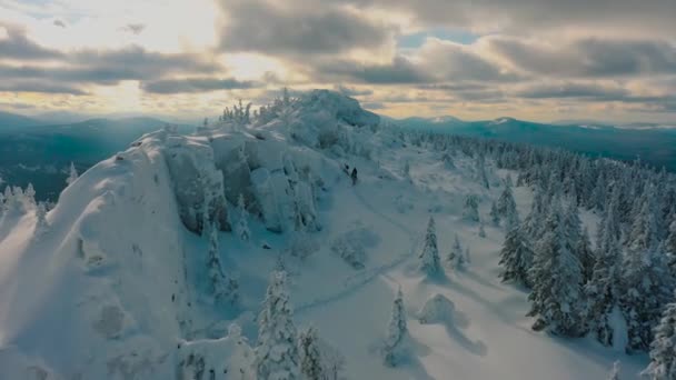 Воздух: группа туристов, поднимающихся на вершину снежного горного хребта — стоковое видео