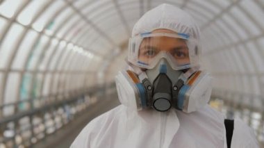 Koruyucu giysili, gözlüklü ve solunum cihazlı virüs uzmanı portresi