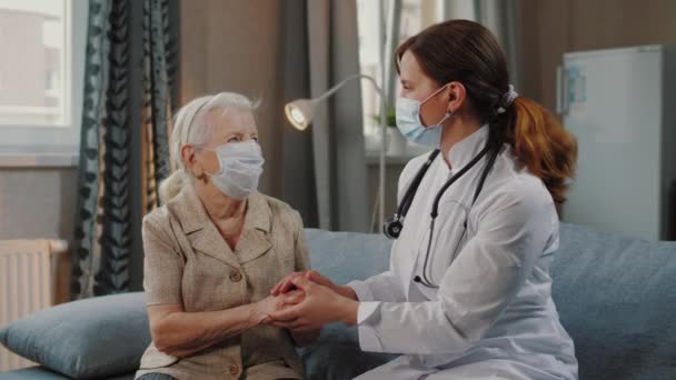 Krankenschwester im Gespräch mit einer älteren Patientin während der Selbstisolation mit Covid-19 — Stockvideo
