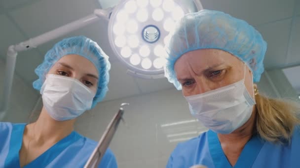 Cirujano y asistente está realizando la operación en la clínica moderna — Vídeo de stock