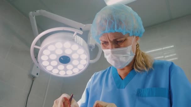 Kvinnlig erfaren kirurg utför operation i modern klinik — Stockvideo