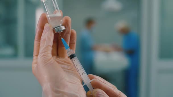 Le mani dei medici riempiono la siringa di medicinale liquido dal flacone di vetro del vaccino — Video Stock