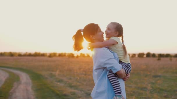 Мама держит милого ребенка на руках, на закате, обнимает друг друга, замедленная съемка — стоковое видео