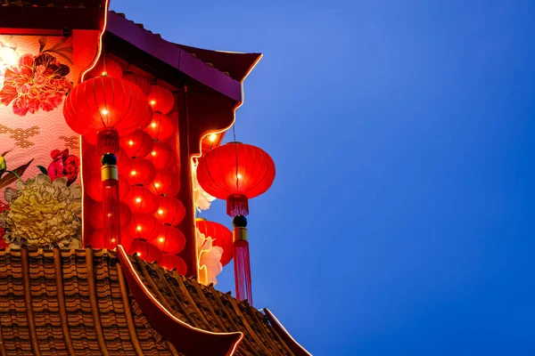 Linternas rojas chinas decoraciones de año nuevo lunares colgando en el techo del templo con cielo azul oscuro en el fondo . —  Fotos de Stock