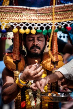 Cavadi taşıyan ve Thaipusam Festivali 'nde ayin yapan adamların yakın çekimi..