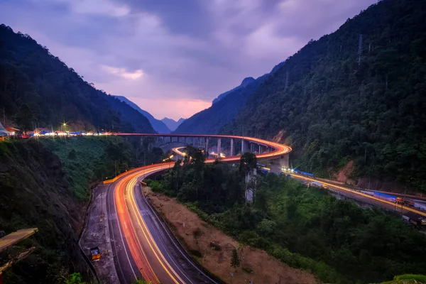 Beautiful light trail in the stretch of winding road of Kelok 9 in the evening, West Sumatra, Indonesia — Stock Photo, Image