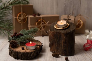 Ahşap kulübelerde beyaz ve kırmızı mumlar, arka planda şenlik kutuları, yeni yılın atmosferi. Noel kompozisyonu.