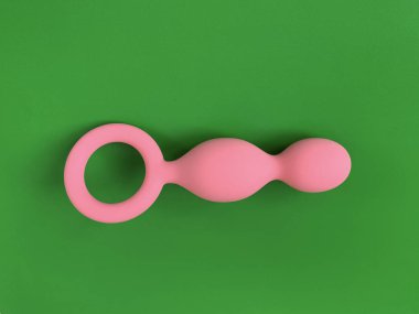 Yeşil arka planda pembe anal tıpa. Seks dükkanı için kullanışlı