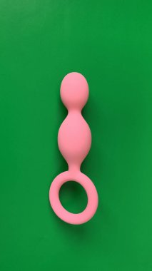 Seks için pembe anal fiş. Seks oyuncağı, yeşil arka planda kıç tıkacı. Anal oyuncak. Seks dükkanı ya da yetişkinler için kullanışlı