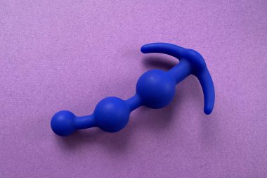 Seks oyuncağı, anal oyuncak. Kıç tıkacı. Seks için mavi anal fiş. Mor arka planda. Seks dükkanı ya da yetişkinler için kullanışlı