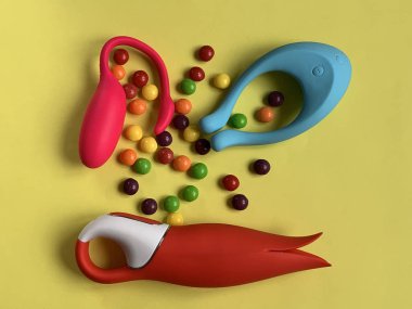 Vibratörler. Sarı arka planda üç seks oyuncağı. Seks dükkanı ya da yetişkinler için kullanışlı