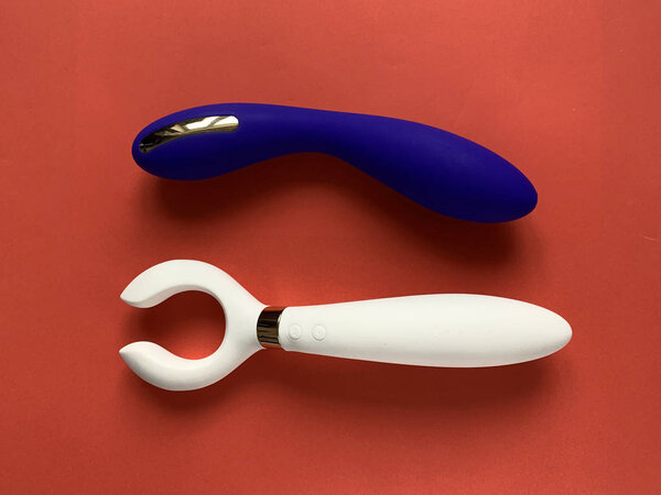 Two vibrators on a red background. Sex toys. Useful for adult