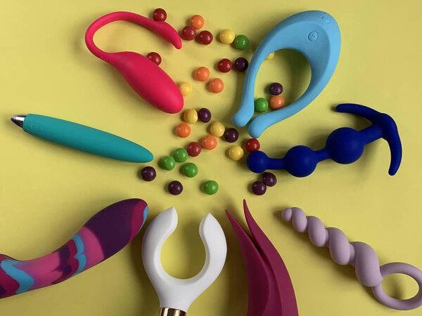 Many sex toys. Vibrators and anal plugs on a yellow background. Useful for sex shop or adults