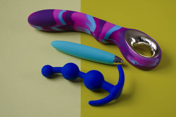 Vibrators and anal plug. Three sex toys on a yellow background. Useful for sex shop or adults
