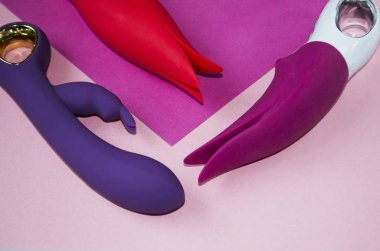 Vibratörler. Pembe arka planda titreşimli seks oyuncakları. Titreşimli dildolar. Yetişkinler için kullanışlı, seks dükkanı