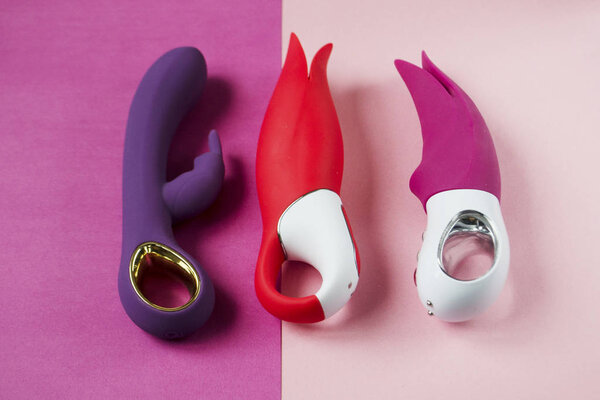 Three vibrators on bright background. Sex toys on pink background.