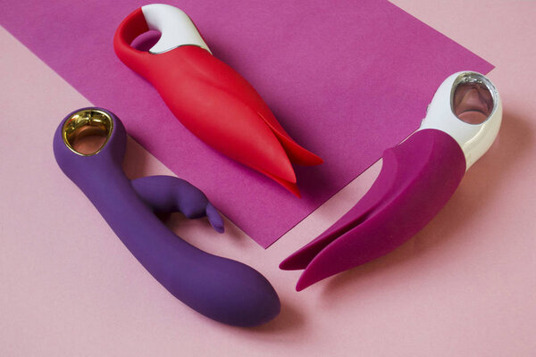 Vibrators. Three sex toys on bright background. Red, pink and purple intim toys. Image for the sex shop