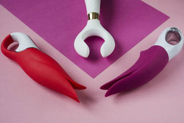 Vibrators. Three sex toys on bright background. Red, pink and white intim toys. Image for the sex shop