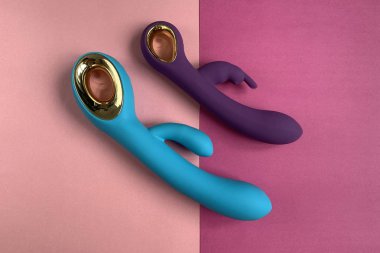 Vibratörler. Pembe arka planda titreşimli iki vajinal dildo. Seks oyuncakları. Yetişkinler için kullanışlı, seks dükkanı. Yakın plan.