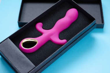 Seks oyuncağı. Mavi arka planda pembe vibratör. Seks dükkanı için kullanışlı