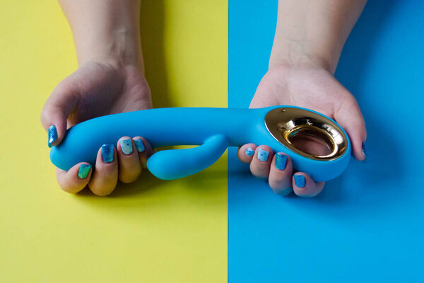 Sex toy. Blue vibrator on a hand. Useful for sex shop