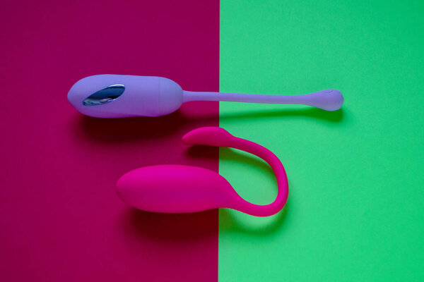 Sex toys. Two ben wa balls on a pink/green background. Useful for sex shop