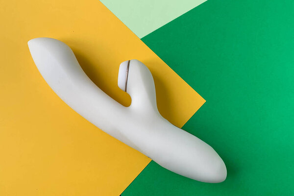 Sex toy. White Vibrator on a yellow-green background. Useful for sex shop, adult