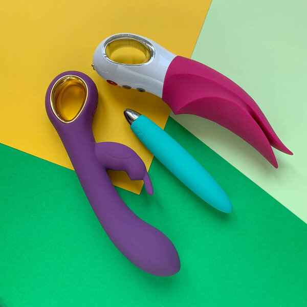 Ассортимент магазинов для взрослых. Три вибратора на цветном фоне. Полезно для взрослых, секс-шоп
