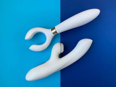 Seks oyuncakları. Mavi arka planda iki beyaz vibratör. Yetişkinler için kullanışlı, seks dükkanı