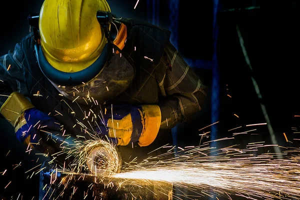 the worker cuts the electric grinder