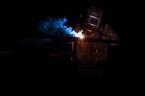 Soudeur soude un garage métallique la nuit Images De Stock Libres De Droits