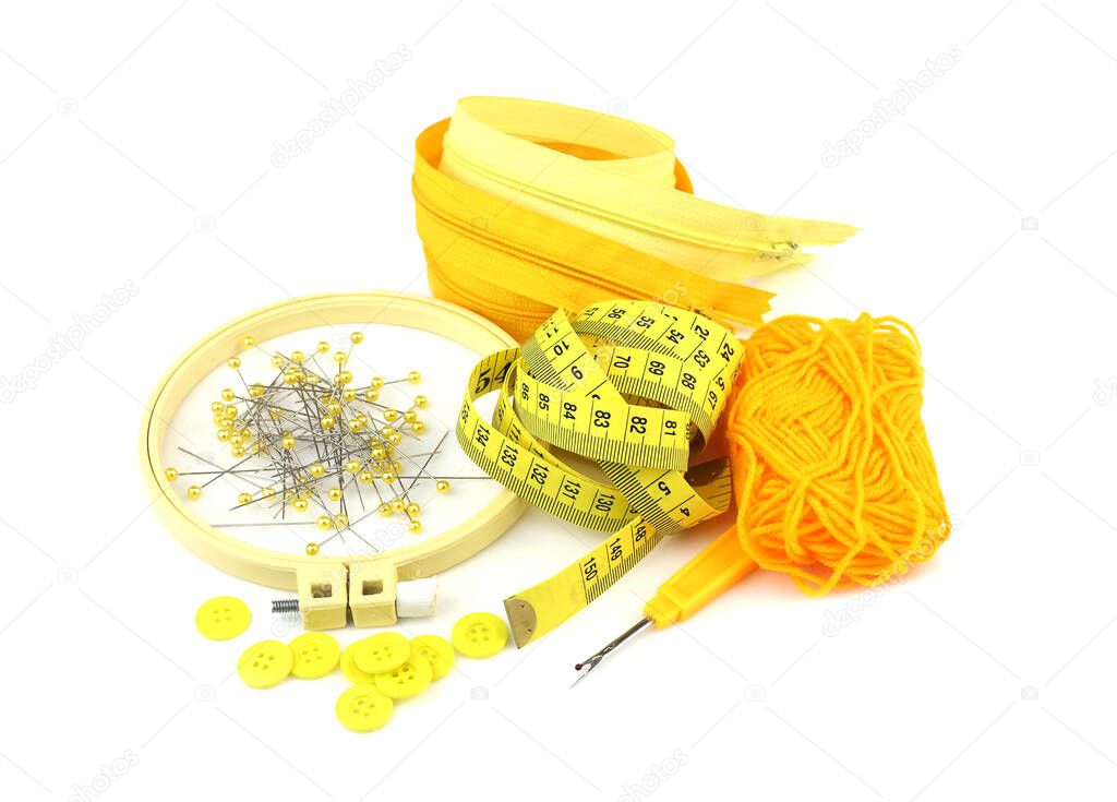 Yellow pin,button,yarn,zipper and sewing tools isolated on white backgroun
