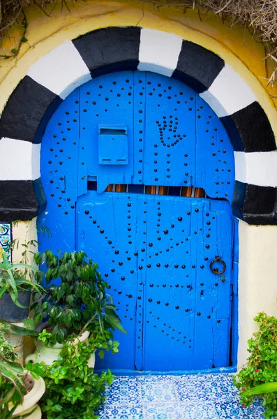 Diseño oriental puerta azul con un patrón en una pared de arcilla —  Fotos de Stock