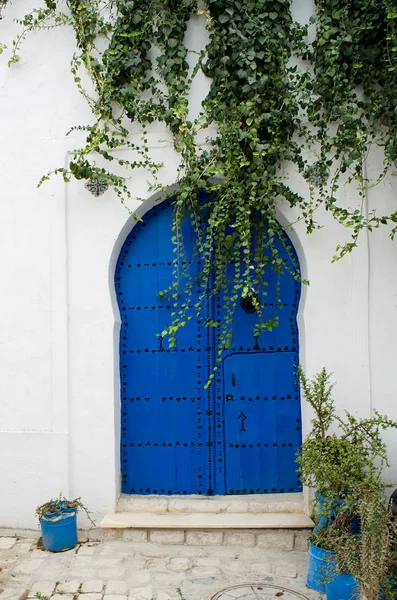 Diseño oriental puerta azul con un patrón en una pared de arcilla —  Fotos de Stock
