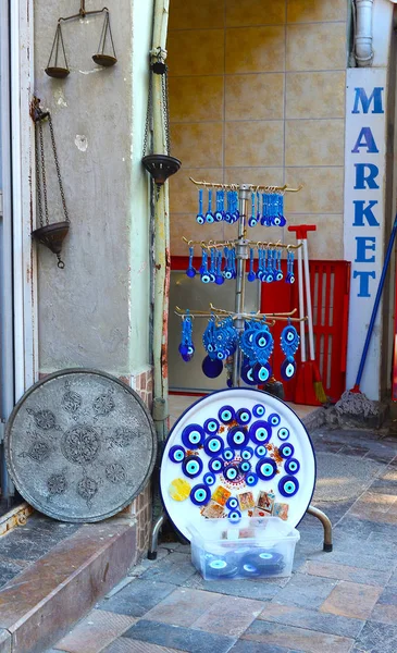 Escamas antiguas, plato de metal y amuletos turcos en la entrada de la tienda de recuerdos —  Fotos de Stock