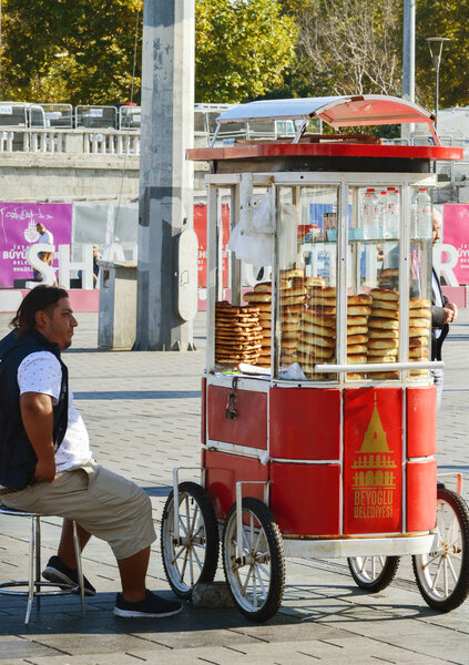 Istanbul, TURKEY, September 18, 2018. Seller of traditional Turkish bagels - simits siting next to a truck in Taksim Square