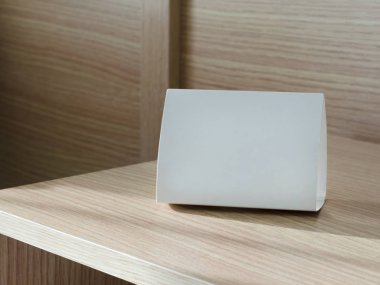 Açık kahverengi rafta fotokopi alanı olan beyaz tabela.