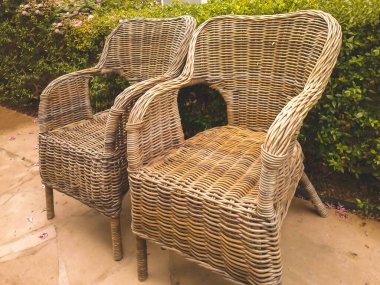 İki hasır sandalye yaz bahçesinde yan yana durur.