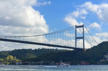 Part of a cable-stayed bridge over the Bosphorus and coast guard boat in the afternoon