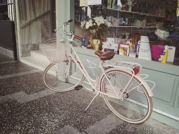 Стамбул, ТУРКЕЙ - 21 - 2018: Розовый городской велосипед с корзиной перед аптечной витриной — стоковое фото