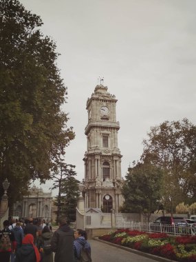 İstanbul, Türkiye - 25 Eylül 2018. Bir grup Asyalı turist Dolmabahche Sarayı 'nın saat kulesinin yanından geçiyor.