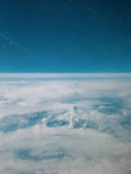 Ice crystals on the window glass of an airplane at high altitude. View above the clouds.