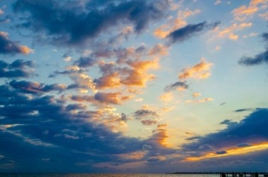 Şafakta denizin üzerinde bulutlar olan güzel bir gökyüzü. Doğal arkaplan