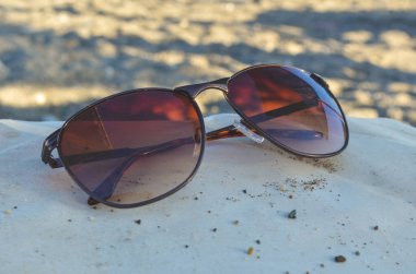 Gölgede unutulmuş güneş gözlükleri plaj şezlongunda