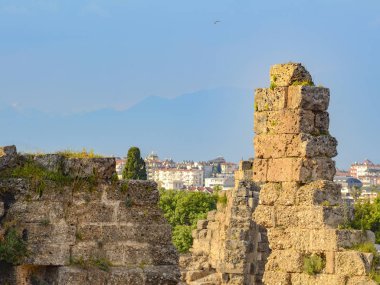 Antik şehrin kalıntıları modern kasabanın ve dağların arka planına yakın. Yıkım ve yeniden doğuş kavramı